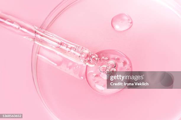 close-up pipette with face serum or essential oil with oxygen aqua bubbles and petryi dish on pastel pink color background. - duschgel nobody stock-fotos und bilder