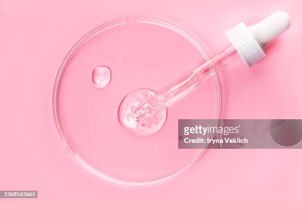 close-up pipette with face serum or essential oil with oxygen aqua bubbles and petryi dish on pastel pink color background. - gel pour les cheveux photos et images de collection