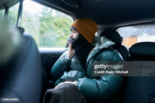 sitting in back seat of car on cold winter rain day - pouting stock pictures, royalty-free photos & images