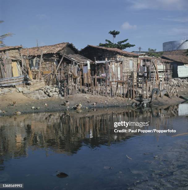 Shacks constructed from wood, stones and tiles beside a waterway in a shanty town built near the beach in the city of Fortaleza in the state of Ceara...