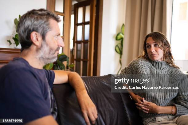 couple looking at each other with sad expression during couple's therapy session - fighting couple stock-fotos und bilder