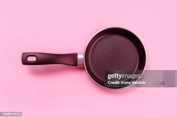 cooking pan on pastel pink color background. - sartenes fotografías e imágenes de stock