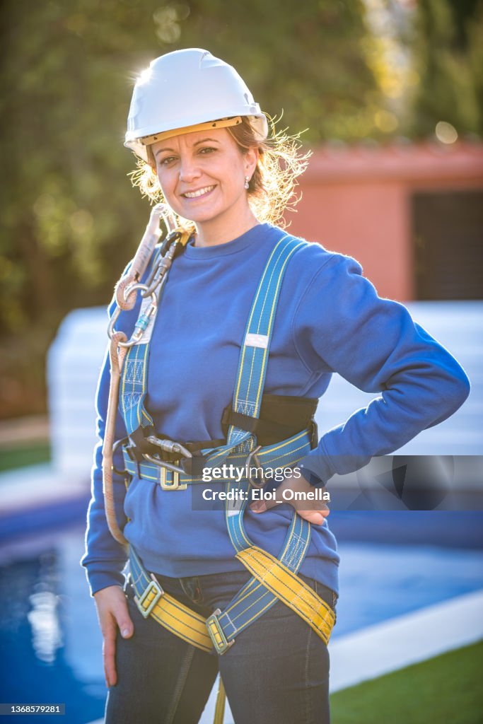 Female Worker ready to work putting on safety harness