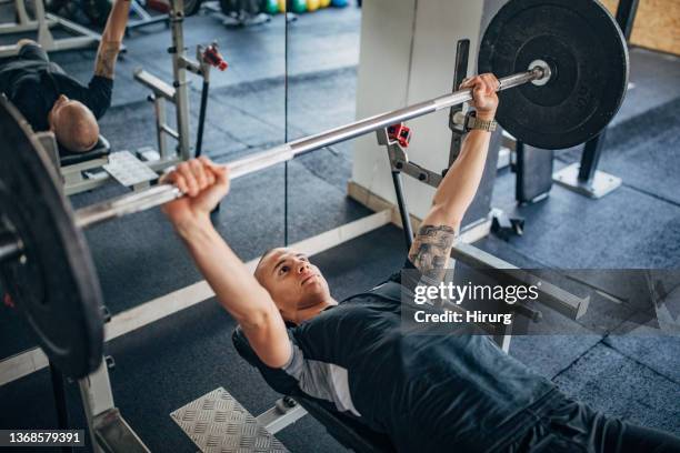 man training on bench press - workout bench stock pictures, royalty-free photos & images