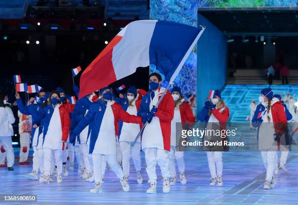 Flag bearers Kevin Rolland and Tessa Worley of Team France carry their flag during the Opening Ceremony of the Beijing 2022 Winter Olympics at the...