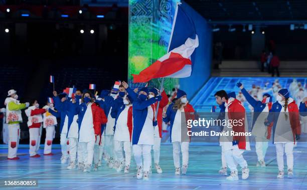 Flag bearers Kevin Rolland and Tessa Worley of Team France carry their flag during the Opening Ceremony of the Beijing 2022 Winter Olympics at the...