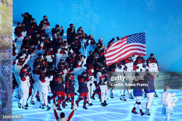 Flag bearers Brittany Bowe and John Shuster of Team United States carry their flag during the Opening Ceremony of the Beijing 2022 Winter Olympics at...