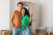 Happy couple showing keys from flat on moving day