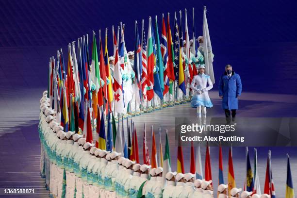 Thomas Bach, IOC President walks alongside flags of each participating country during the Opening Ceremony of the Beijing 2022 Winter Olympics at the...