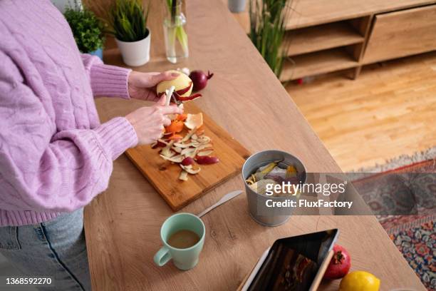 high angle view of unrecognizable woman peeling the apple with peeler - peeling food stock pictures, royalty-free photos & images