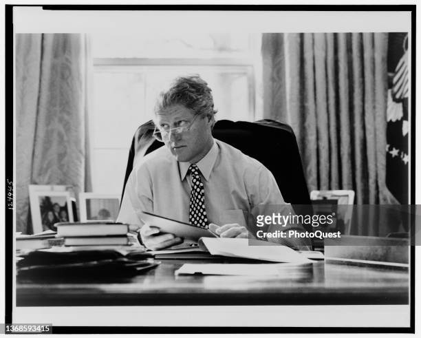 View of American politician US President William J Clinton as he sits behind his desk in the White House's Oval Office, Washington DC, 1993.