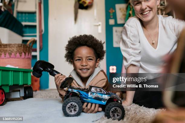 young boy playing with remote controlled car in bedroom - remote controlled 個照片及圖片檔