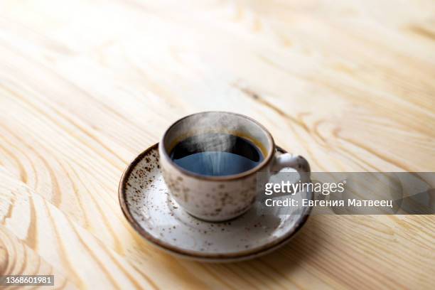 coffee espresso cup on wooden table background. sunny morning breakfast concept. close up. - black coffee stock pictures, royalty-free photos & images