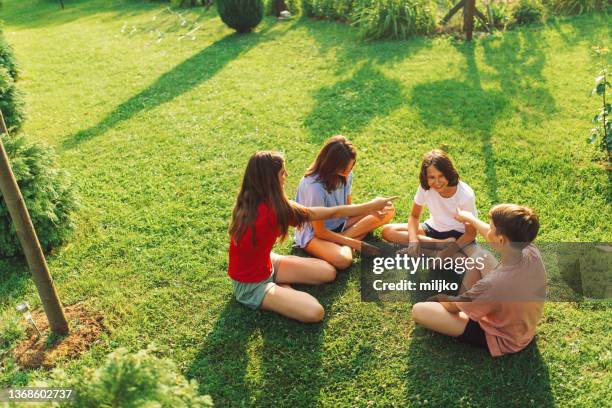 gruppe von kindern, die handspiel im hinterhof spielen - teen boy barefoot stock-fotos und bilder