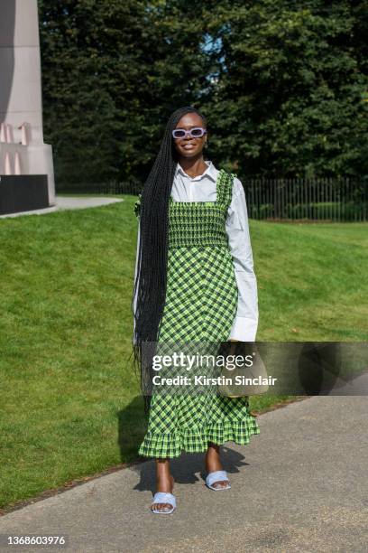 Deborah Ababio wears a Ganni dress, Burberry shirt, JW Pei bag and Jimmy Fairly sunglasses during London Fashion Week September 2021 on September 20,...