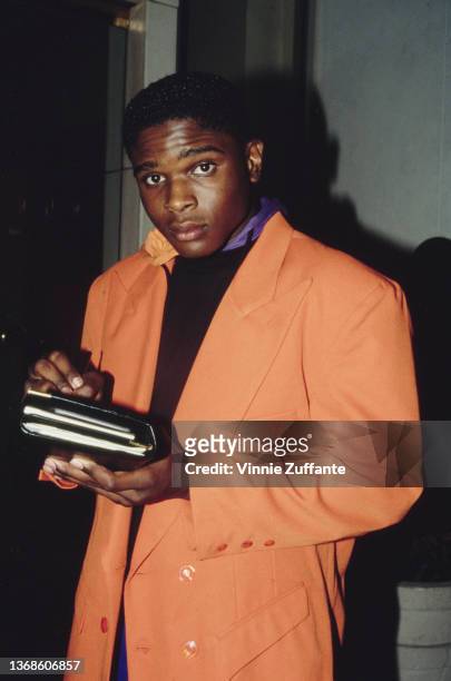 American actor Darius McCrary wearing a peach-coloured blazer over a black sweater, a personal organiser in his hands, circa 1995.
