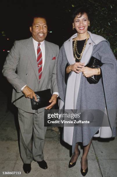 America musician Billy Davis Jr, wearing a grey suit with a deep red diagonally-striped tie, and his wife, American singer and actress Marilyn McCoo,...