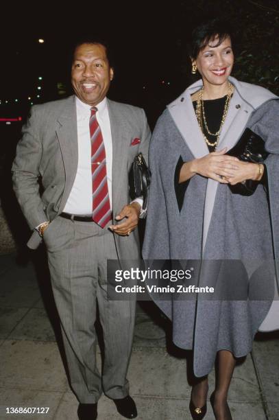 America musician Billy Davis Jr, wearing a grey suit with a deep red diagonally-striped tie, and his wife, American singer and actress Marilyn McCoo,...