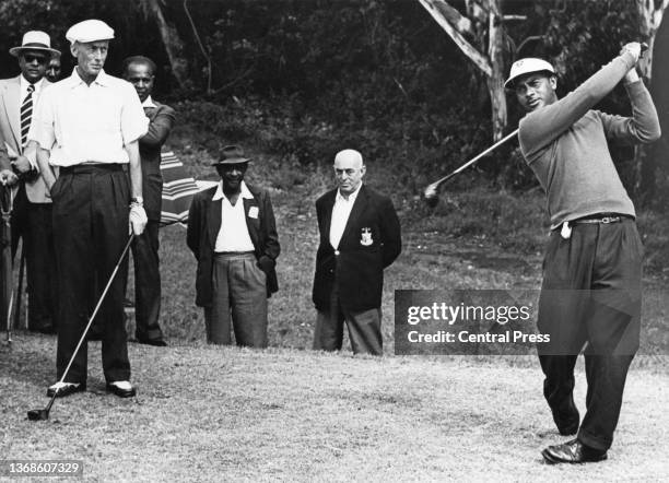 Sewsunker "Papwa" Sewgolum from South Africa of ethnic Indian origin watches his drive shot off the 1st tee during the 1961 South African Open Golf...