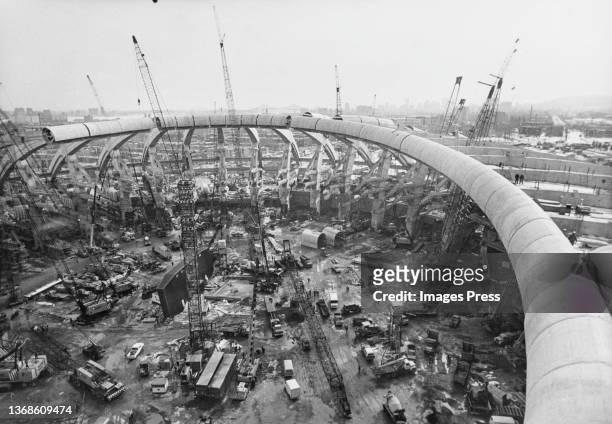 Cranes and construction workers at work on the Olympic Stadium in the Olympic Park in preparation for the 1976 Summer Olympics, in Montreal, Canada,...