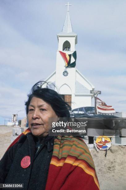 Native American with the Sacred Heart Church in the background during the Wounded Knee Occupation at Wounded Knee on the Pine Ridge Indian...