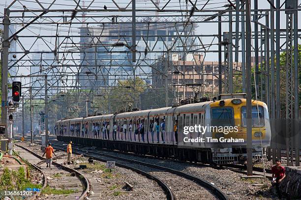 Office workers on crowded commuter train of Western Railway near Mahalaxmi Station on the Mumbai Suburban Railway, India