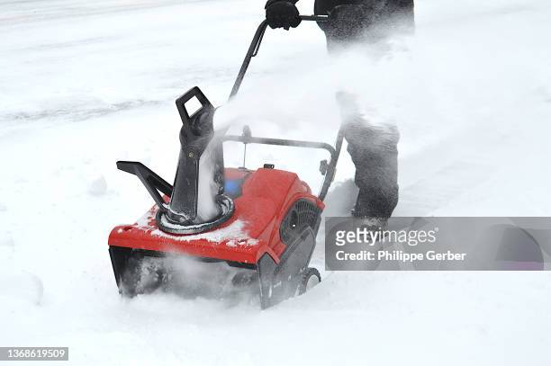 man using snow blower after a snowstorm in pennsylvania - sneeuwmachine stockfoto's en -beelden