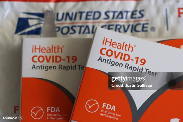 In this photo illustration, free iHealth COVID-19 antigen rapid tests from the federal government sit on a U.S. Postal Service envelope after being...