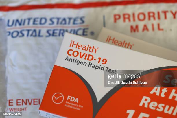 In this photo illustration, free iHealth COVID-19 antigen rapid tests from the federal government sit on a U.S. Postal Service envelope after being...