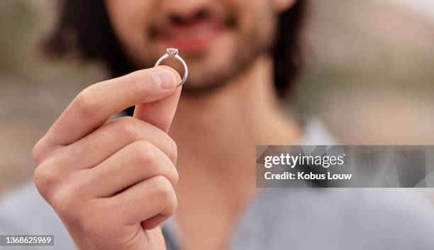 cropped shot of a man holding an engagement ring - man holding engagement ring stock pictures, royalty-free photos & images
