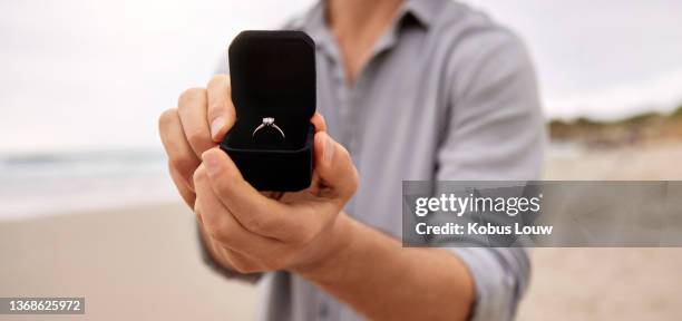 scatto di un uomo che tiene in mano una scatola di gioielli aperta con un anello di fidanzamento - engagement ring foto e immagini stock