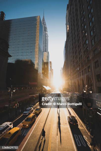 manhattanhenge on the streets of new york city - sunrise new york stock-fotos und bilder