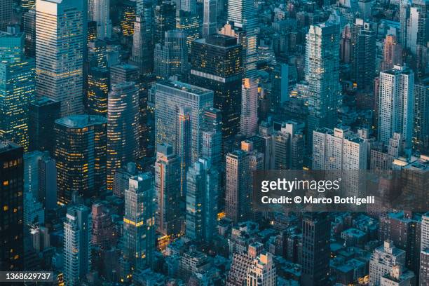 aerial view of new york city skyline at night - urban skyline stock-fotos und bilder