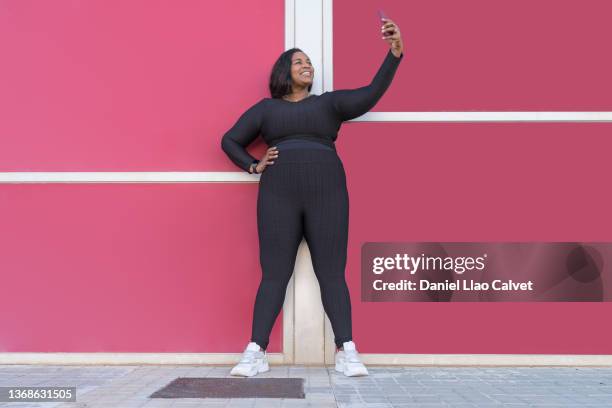 smiling woman on colorful background taking selfie - obesity imagens e fotografias de stock