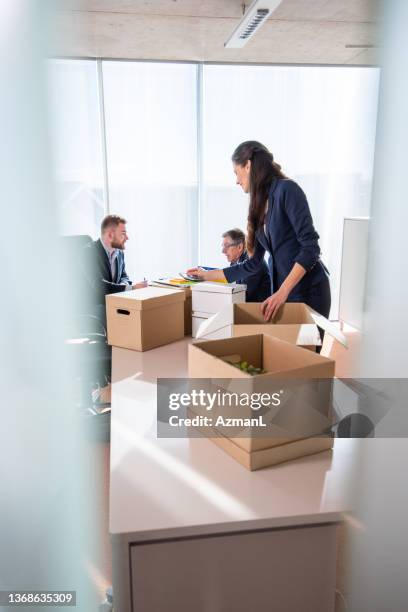 eine kaukasische geschäftsfrau, die einige dokumente im büro organisiert - tidy stock-fotos und bilder