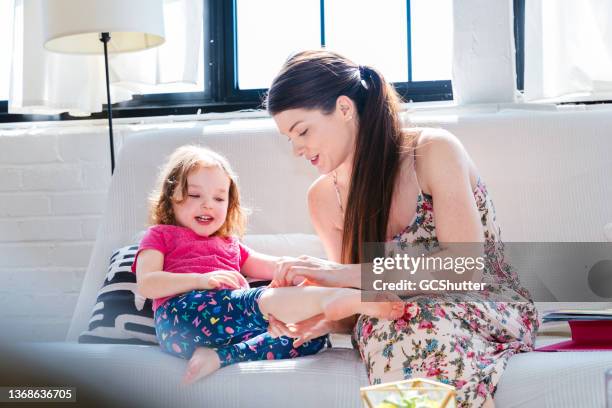 mischievous daughter complaining leg injury to her mother - child support stock pictures, royalty-free photos & images