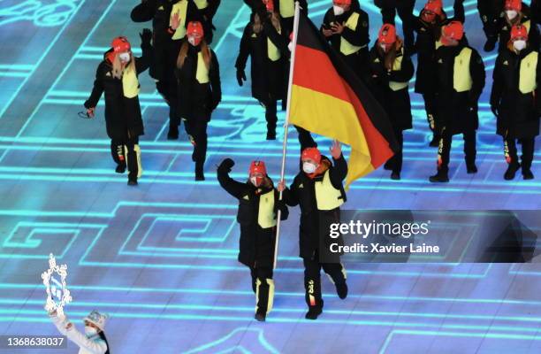 Flag bearers Francesco Friedrich and Claudia Pechstein of Team Germany carry their flag during the Opening Ceremony of the Beijing 2022 Winter...