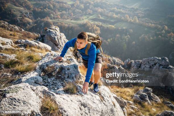 hombre caminando por una montaña - mountaineering fotografías e imágenes de stock