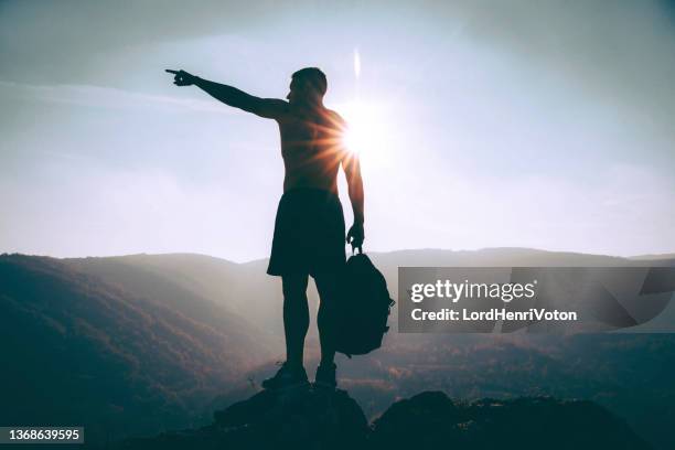 man standing on a mountain and pointing on something - rocky point stock pictures, royalty-free photos & images