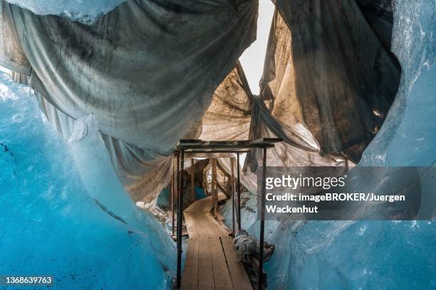 ice grotto of the rhone glacier, covered with white tarpaulins to protect against melting, oberwald, valais, switzerland - plane stock-fotos und bilder