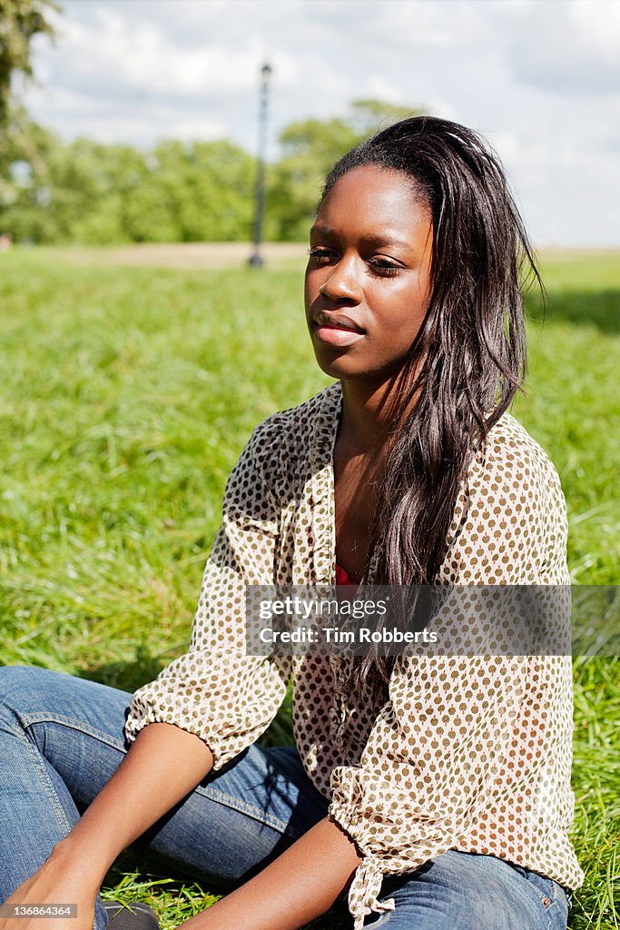 Young woman sat in park.