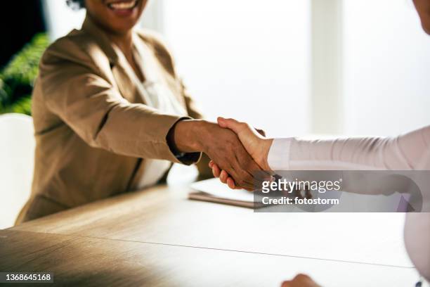 two unrecognizable businesswomen shaking hands after a meeting - handshake stock pictures, royalty-free photos & images