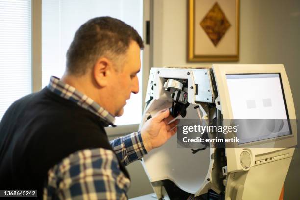 technician repairs ophthalmic device - eye test equipment stock pictures, royalty-free photos & images