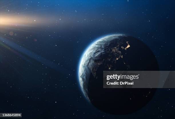 planet earth and sun seen from space. the americas on the night side of the planet - water globe stock-fotos und bilder