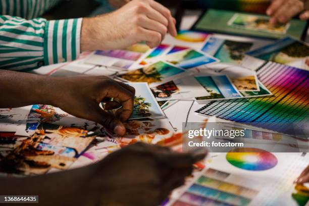 design professionals working with photographs and color swatches - graphic designer stock pictures, royalty-free photos & images