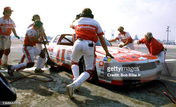Crew Chief Junior Johnson holds NASCAR racer Darrell Waltrip during a pit stop during the Winston Western 500 at Riverside Speedway on way to...