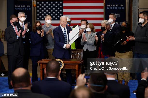 President Joe Biden holds up an executive order about project labor agreements he just signed with Vice President Kamala Harris, Labor Secretary...