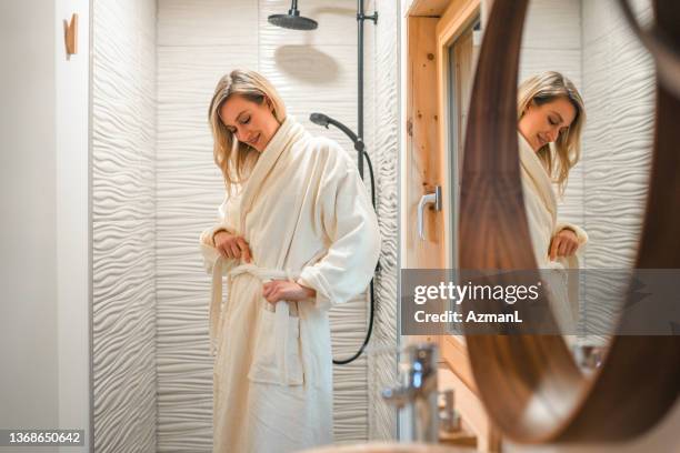 donna caucasica che si gode la sua routine di cura del corpo - accappatoio foto e immagini stock