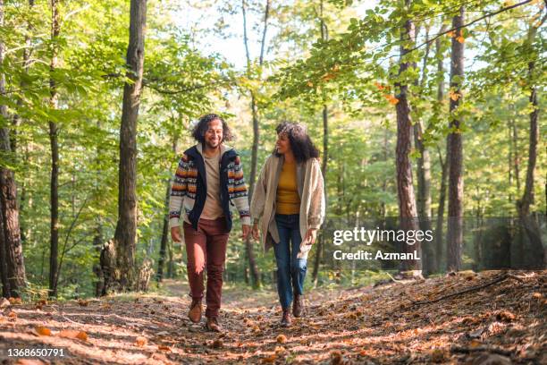 cheerful hispanic couple walking in the woods - idyllic lifestyle stock pictures, royalty-free photos & images