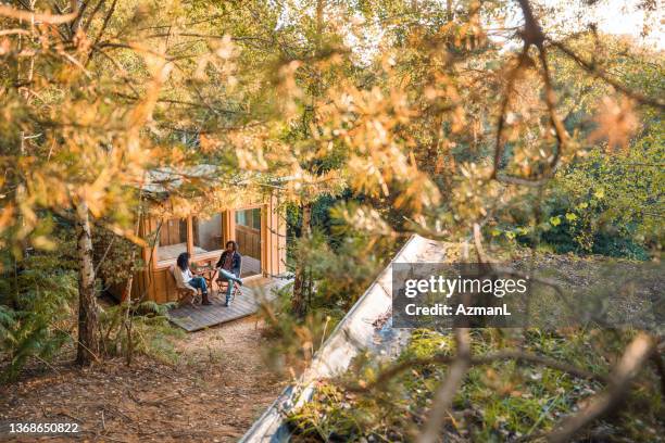 hispanic couple enjoying their coffee on a patio - log cabin stock pictures, royalty-free photos & images